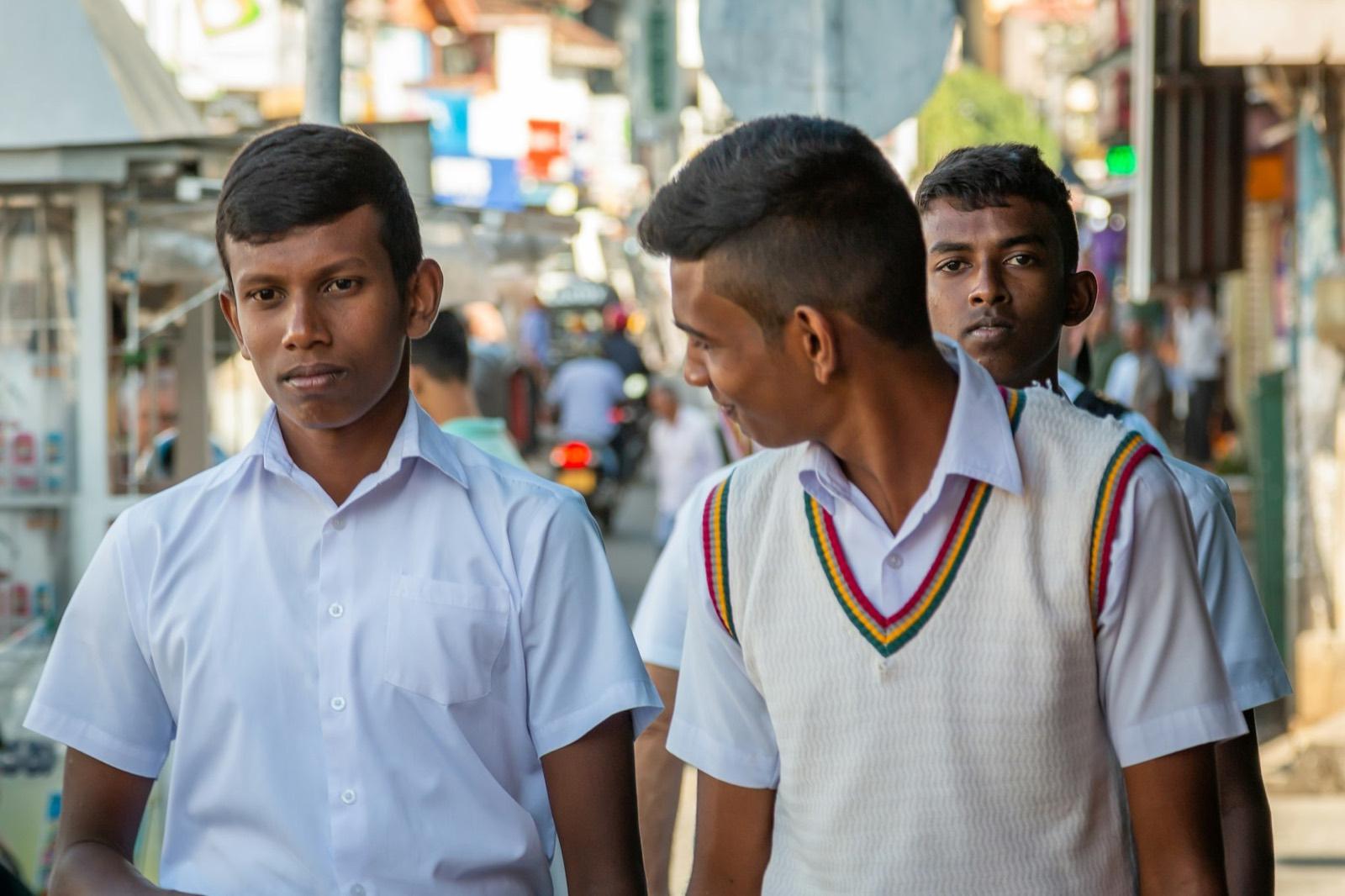 Senior schoolboys in white uniforms on a busy street in Kandy